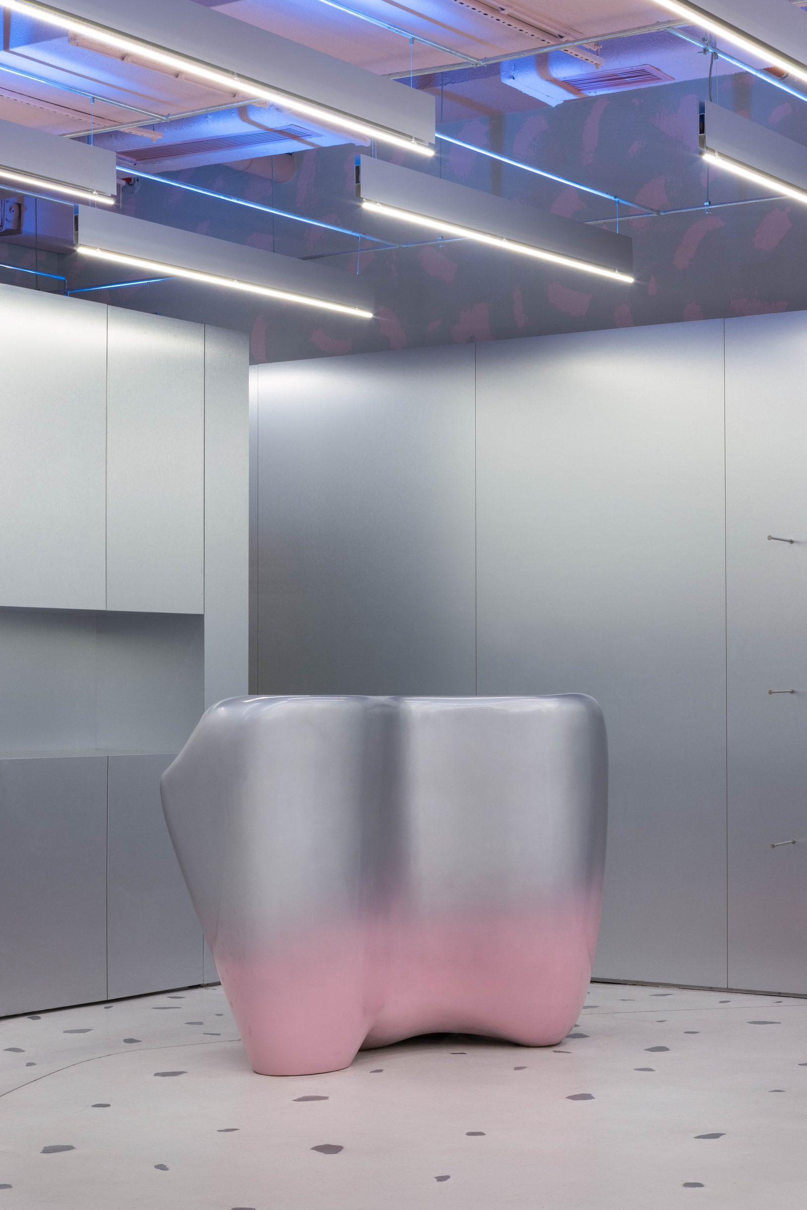 Pembe tabanlı, gümüş renkli heykelsi bir tezgâh